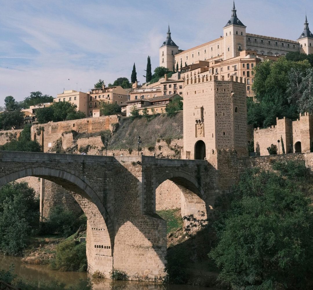 Majestic view of Alcazar with Puente de Alcantara over Tagus River in Toledo, Spain.